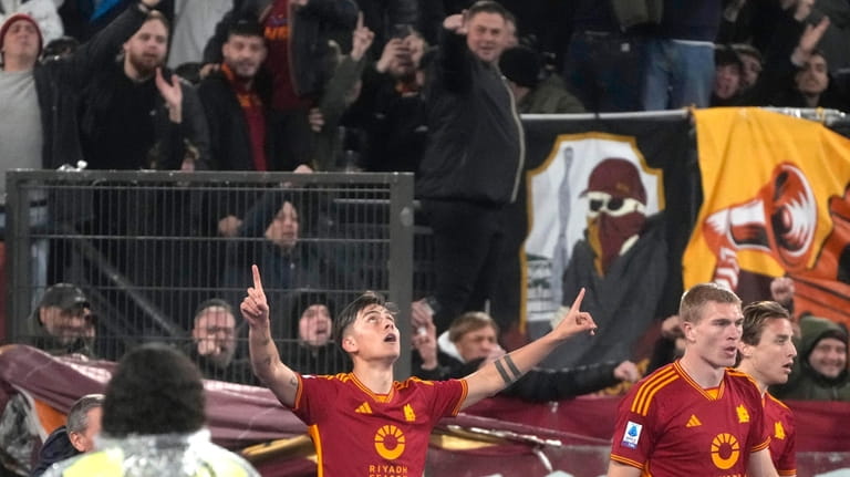 Roma's Paulo Dybala celebrates after scoring his side's third goal...