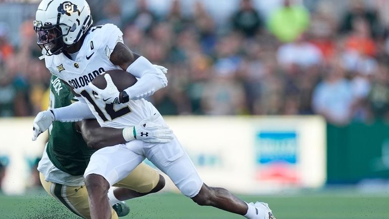 Colorado wide receiver Travis Hunter, front, gets tackled by Colorado...