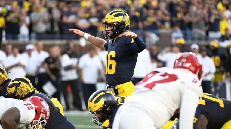 Michigan quarterback Davis Warren signals in the first half of...