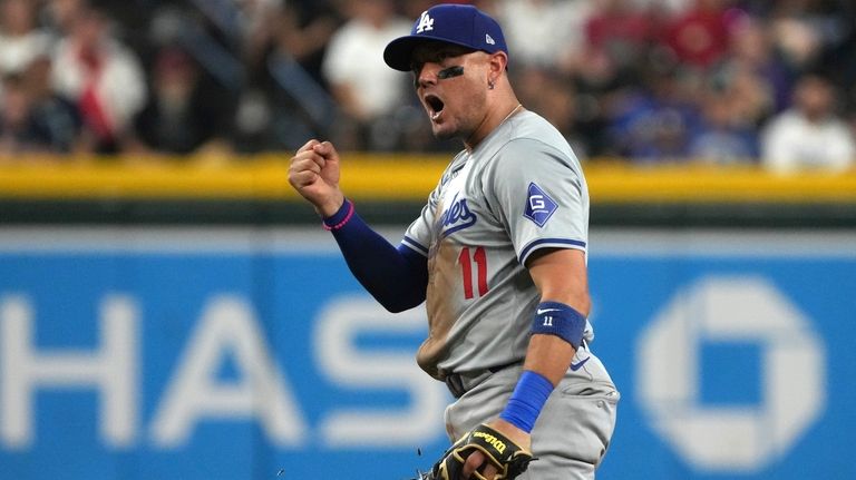 Los Angeles Dodgers shortstop Miguel Rojas reacts after tagging out...