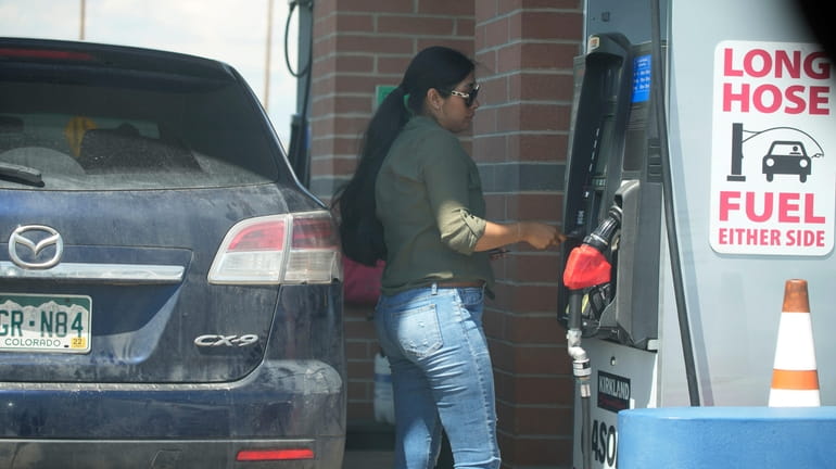 A motorist pays for gasoline at a pump at a...