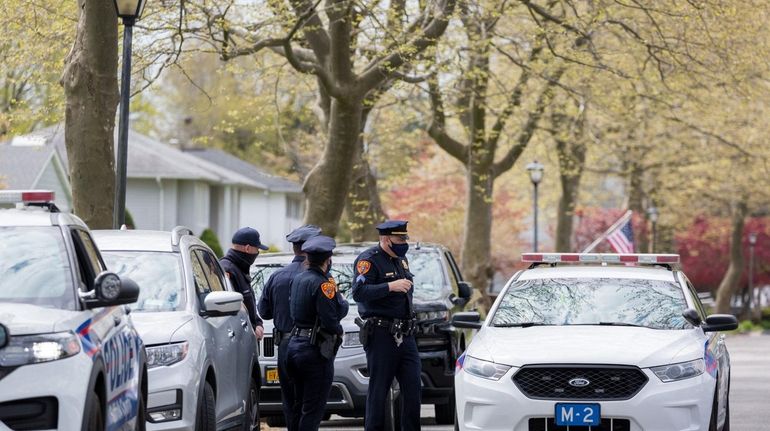 Suffolk County Police Department officers keep watch outside fallen NYPD...