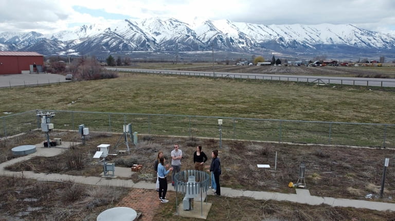 Climate Data Analyst Casey Olson, center left, of Utah State...
