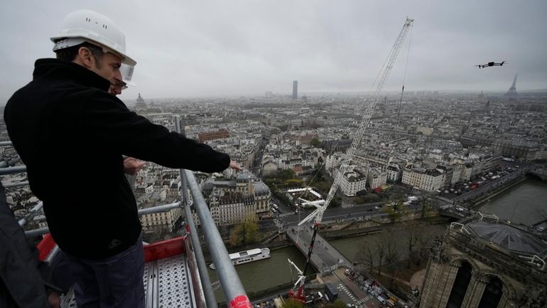 French President Emmanuel Macron watches Notre Dame cathedral from the...