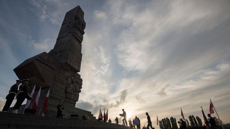 People lay a wreath at the monument to the 1939...