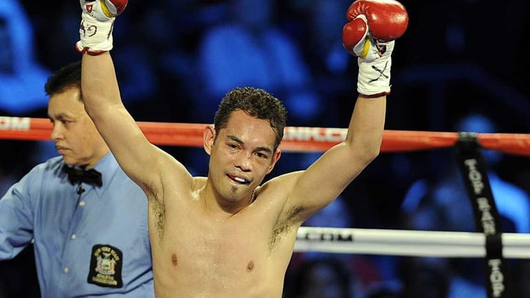 Nonito Donaire raises both his fist after defeating Omar Andres...