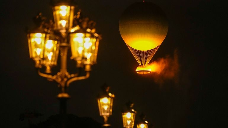 The Olympic Flame rises on a balloon after being lit...