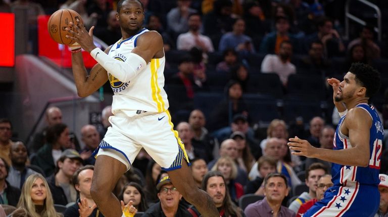 Golden State Warriors forward Jonathan Kuminga, left, passes away from...