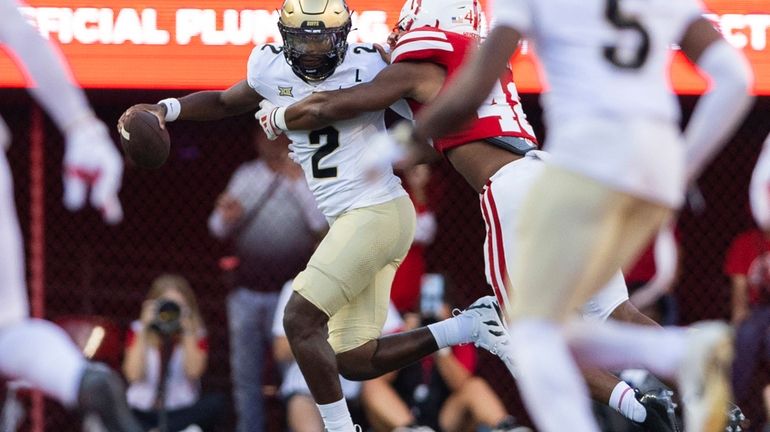 Nebraska linebacker MJ Sherman, back right, tackles Colorado quarterback Shedeur...