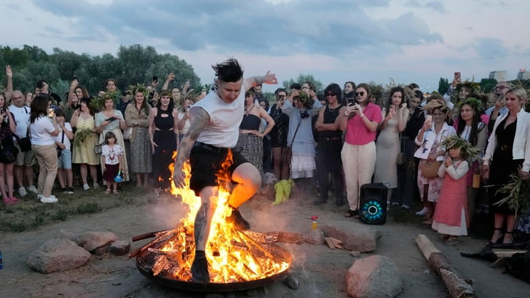 A Ukrainian man jumps over fire during a traditional Ukrainian...