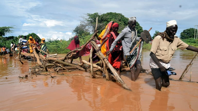 Residents of Chamwana Muma village walk through flood water after...