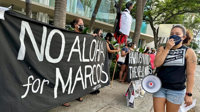 Demonstrators gather outside the Hawaii Convention Center in Honolulu, Saturday,...