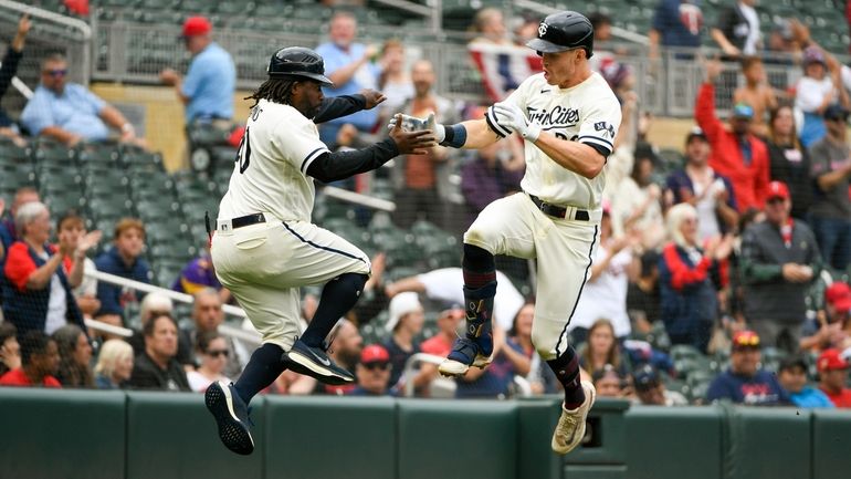 Minnesota Twins' Max Kepler, right, celebrates with third base coach...