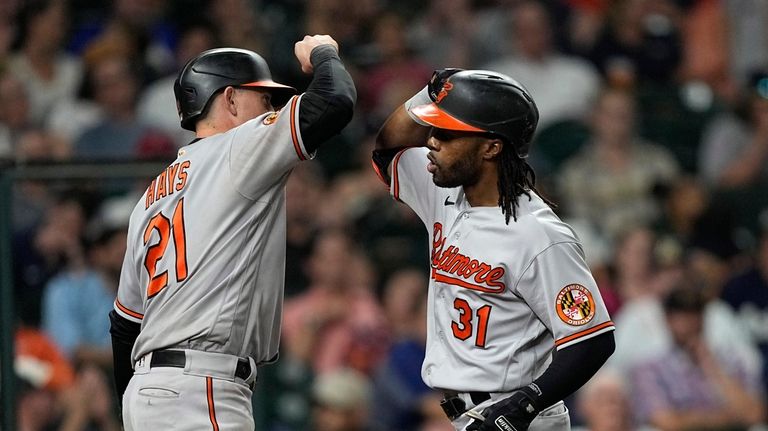 Baltimore Orioles' Cedric Mullins (31) celebrates with Austin Hays (21)...