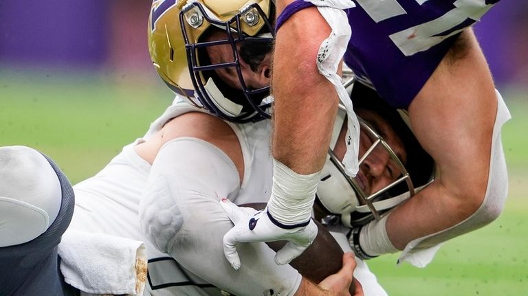 Washington's Carson Bruener (42) makes a late hit against Eastern...