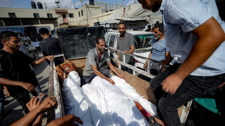 Palestinians gather near the bodies of their relatives killed in...