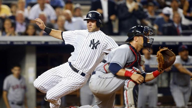 Austin Romine slides past Yan Gomes #10 of the Cleveland...