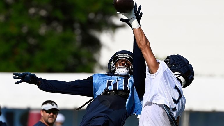 Tennessee Titans cornerback Caleb Farley, right, breaks up a pass...