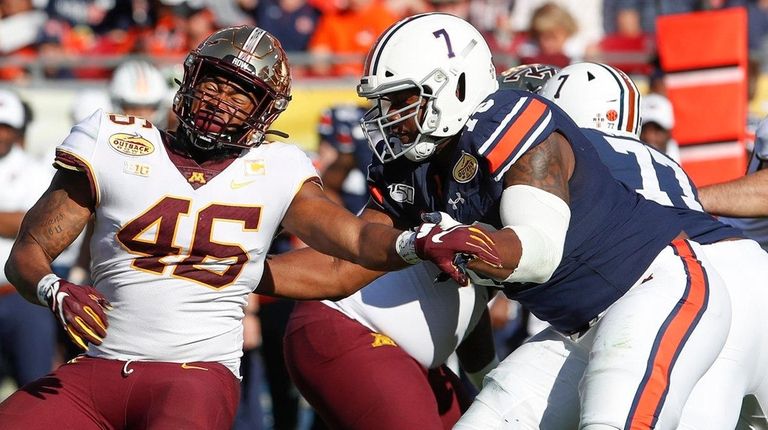 Minnesota Golden Gophers defensive lineman Winston DeLattiboudere is blocked by...