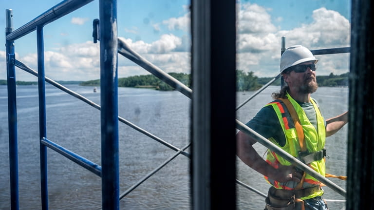 DJ Dorbert works on building scaffolding at the Hudson-Athens Lighthouse,...