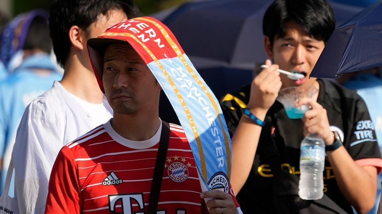 A supporter wearing a match banner to protect from the...