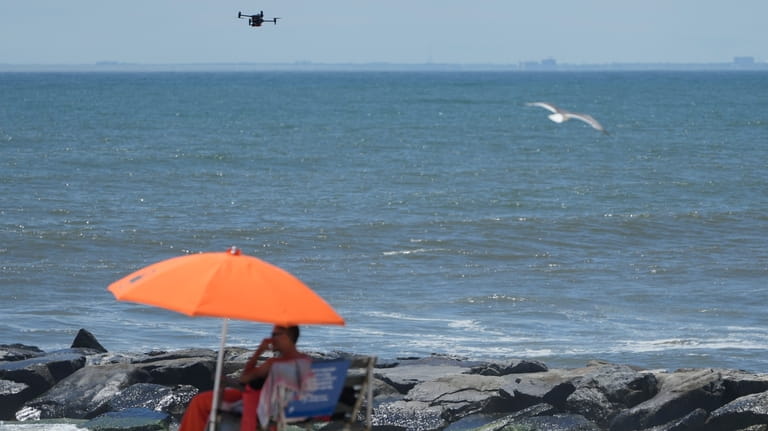 A drone scans the shoreline for signs of struggling swimmers,...