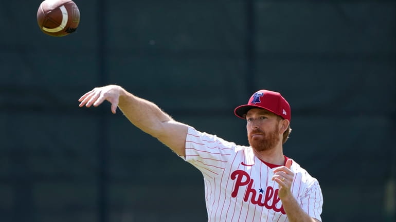 Philadelphia Phillies pitcher Spencer Turnbull throws a football during a...