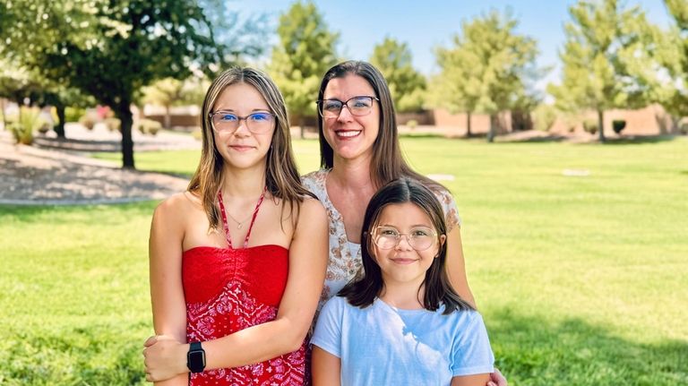 Audrey Jost stands with her daughters, Ellora, left, and Robyn,...