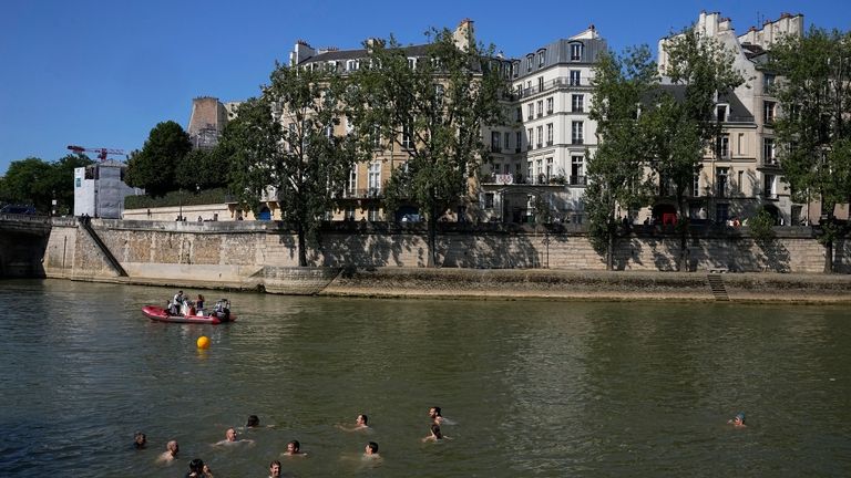 People swim in the Seine river after Mayor Anne Hidalgo...