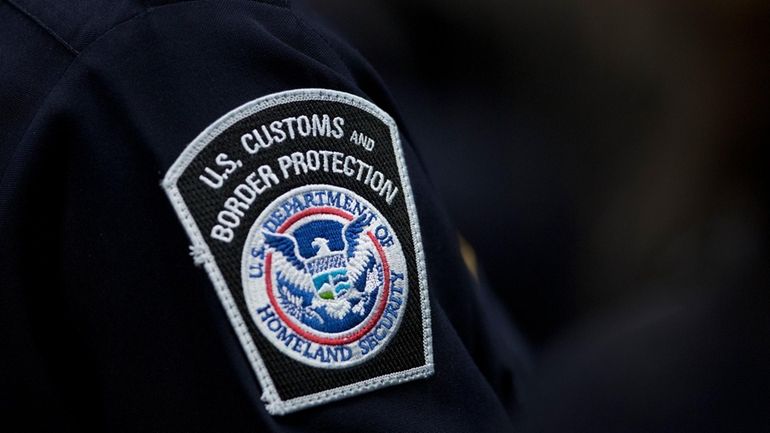 A customs agent wears a patch for the U.S. Customs...