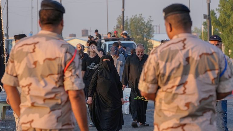 Iraqi Army soldiers stands guard during a march by Shiite...