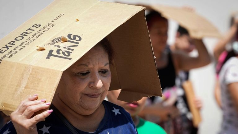 Margaret Cantu waits in the heat for food and water...