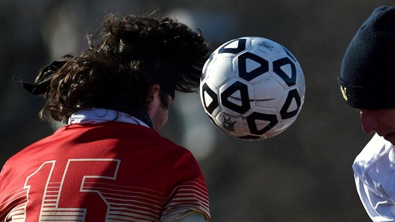 Two players go for a header during a Suffolk County high...