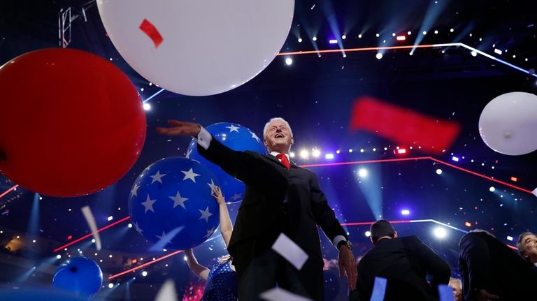 Former President Bill Clinton smiles as balloons fall during the...