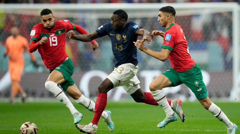 France's Youssouf Fofana, center, vies for the ball with Morocco's...