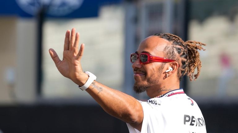 Mercedes driver Lewis Hamilton of Britain, waves as he arrives...