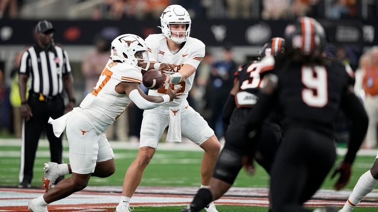 Texas quarterback Arch Manning (16) hands the ball off to...