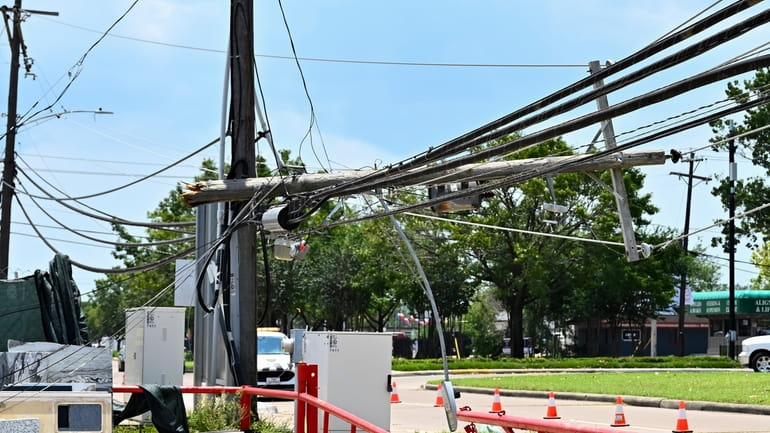 Utility polls wait for repair after being damaged by Hurricane...
