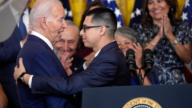 Javier Quiroz Castro gives a hug to President Joe Biden...