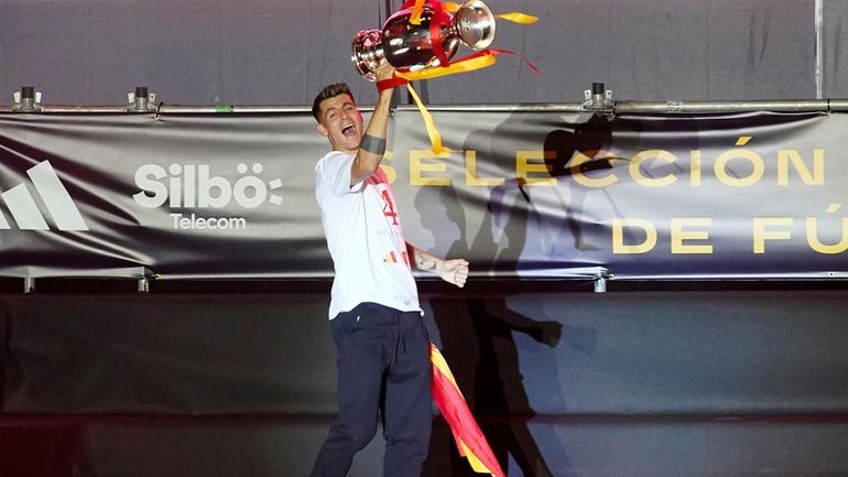 Spain's team captain Alvaro Morata arrives on stage carrying the...