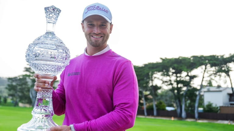 Wyndham Clark holds the trophy after winning the AT&T Pebble...