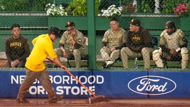 A member of the PNC Park ground crew squeegees water...