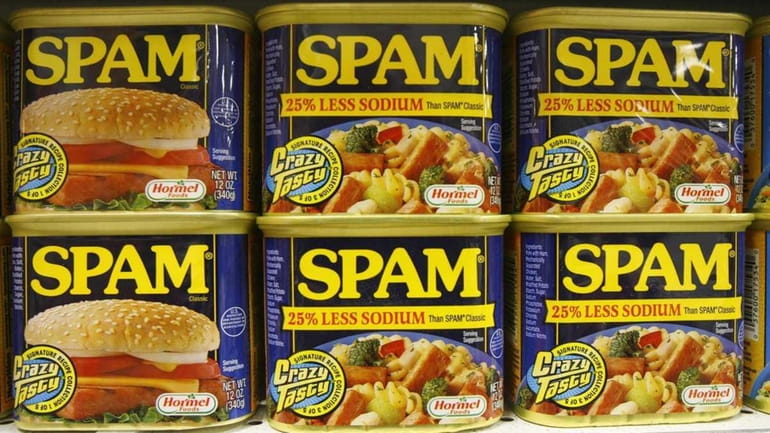 Cans of Spam line the shelves at a store in...