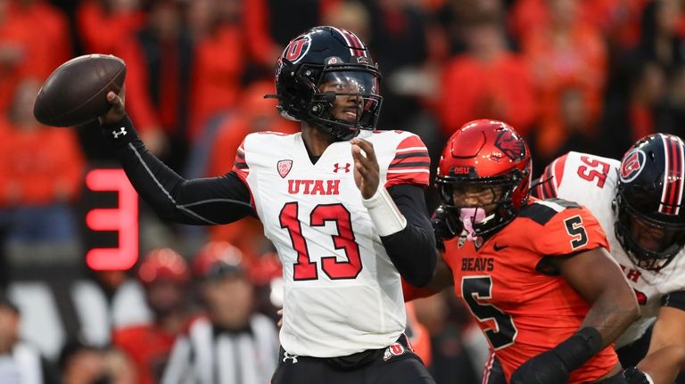 Utah quarterback Nate Johnson (13) drops back to pass against...