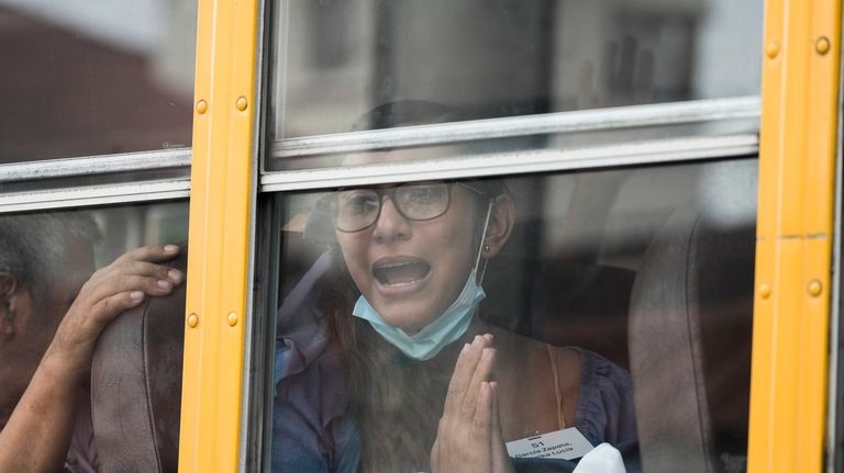 Lucia Garcia gestures from a bus after being released from...