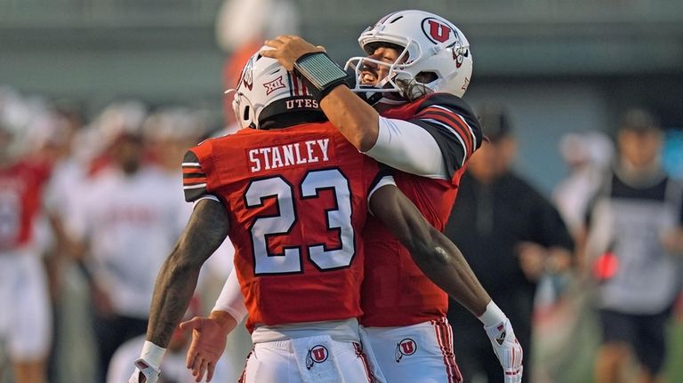 Utah quarterback Cameron Rising, right, celebrates with running back Dijon...