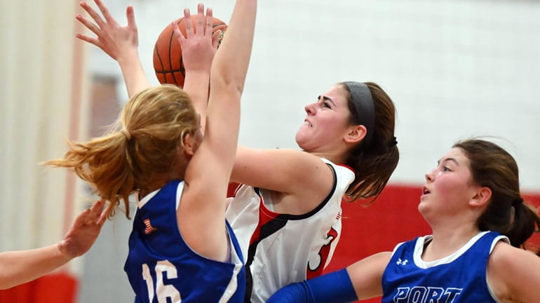 Carly Greenbaum of Syosset drives between the defense of Goldie...