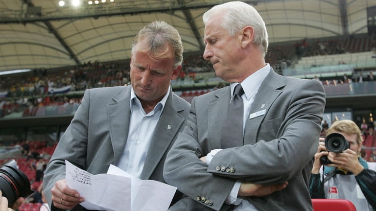 Stuttgart coach Giovanni Trapattoni sits beside assistant Andreas Brehme, left,...
