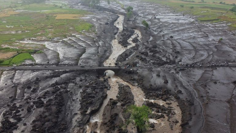 People examine the damage at an area badly affected by...