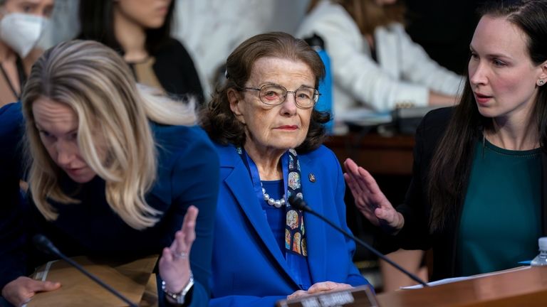 Sen. Dianne Feinstein, D-Calif., is flanked by aides as she...